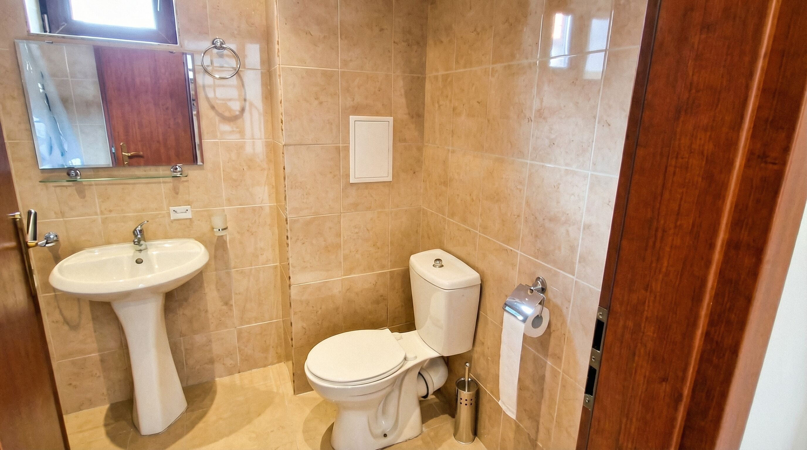 Een badkamer met een wastafel, toilet en spiegel.