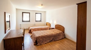 A bedroom with two single beds, a wooden dresser, a desk, and a mirror. - Penthouse Duplex Large 2 Bedroom MP1 (Bansko)