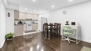 Um apartamento moderno com cozinha, área de jantar e um pequeno espaço de escritório.