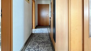 A hallway with patterned flooring, wooden doors, and a framed picture on the wall. - Cozy vacation apartment "Talblick" in Eibenstock, district Carlsfeld (Eibenstock)
