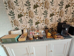 A kitchen counter with a coffee machine, a toaster, a kettle, and various food items. - LE CHALET DES PINS (Clermont)
