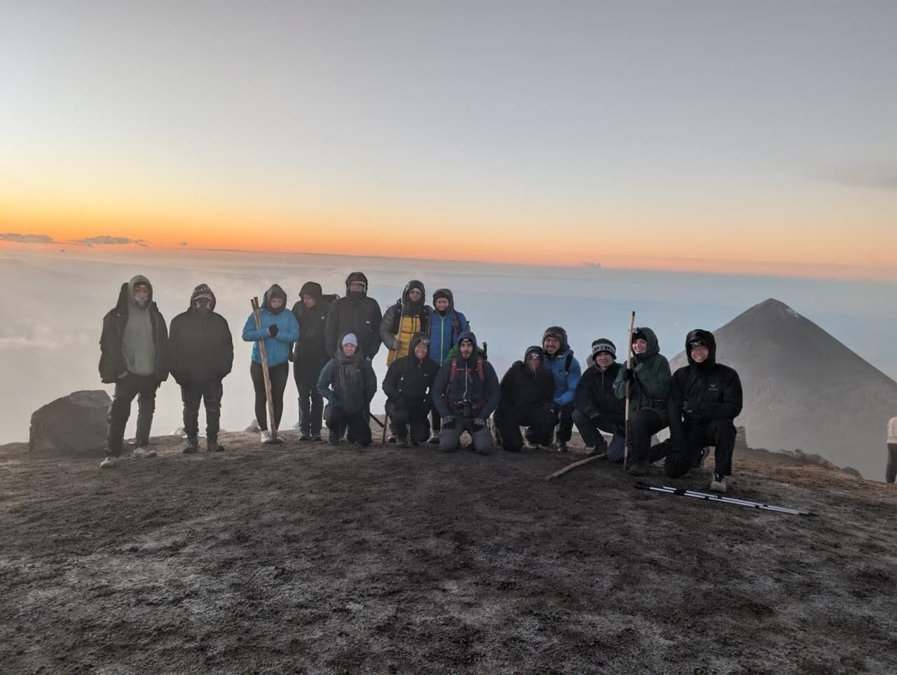 A group of people on a mountain peak with a clear sky.