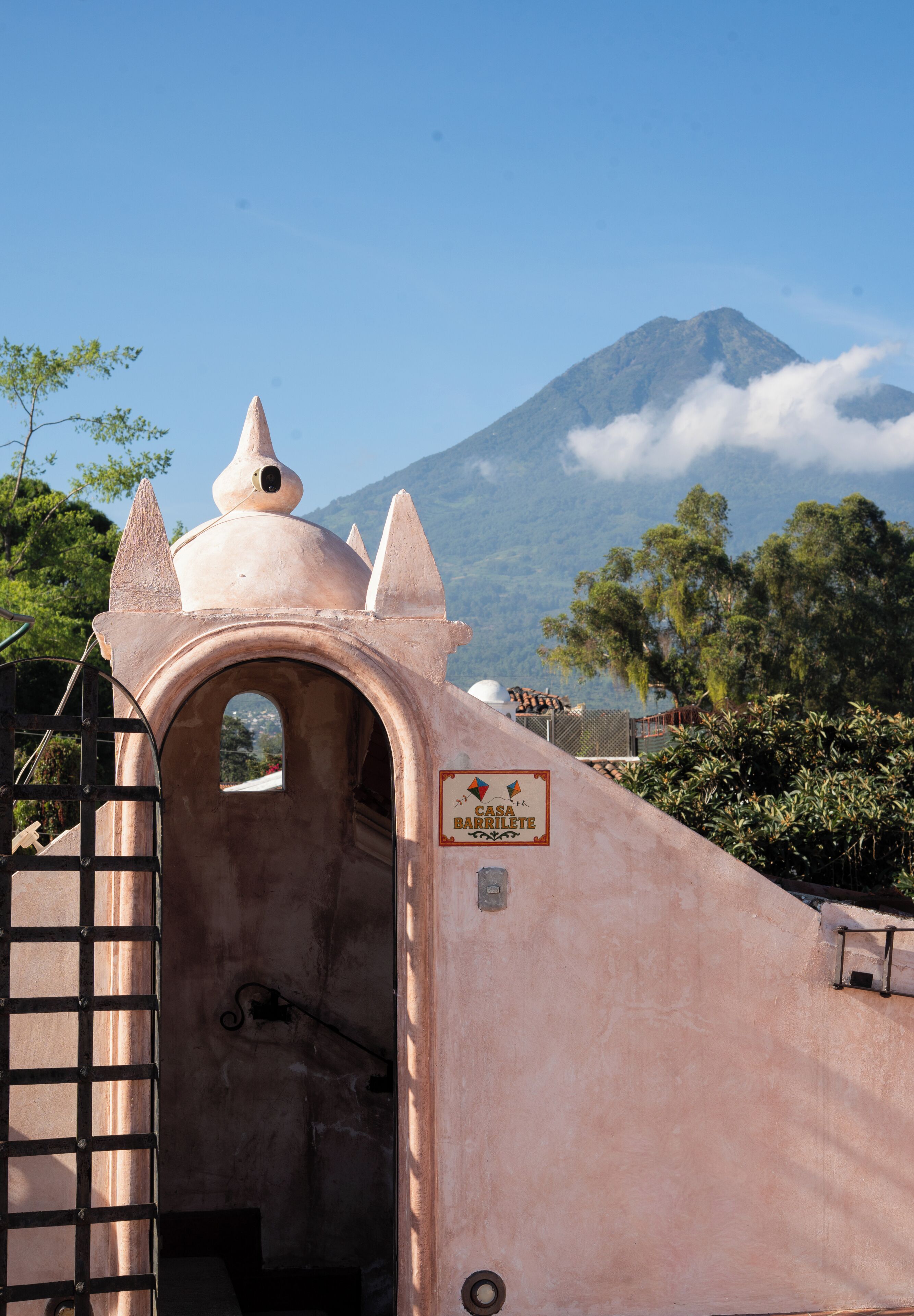 A building with a sign reading 'Casa Barrilete' and a view of a mountain in the background.