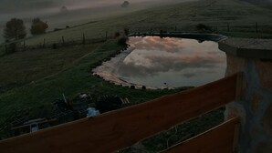 A rural landscape with a sunrise or sunset, a small pond, and rolling hills. - Wooden house in the middle of nature with a wonderful panorama, near to Budapest (Penc)