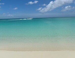 A beach with clear turquoise water and a white sandy shore.