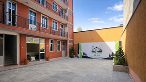 A courtyard with a reception area, a guest house, and a large banner advertising 'SAFE LAND'. - Safe Land Guest House  (Mek'ele)