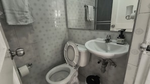 Un bagno con il water, un lavandino e uno specchio.
