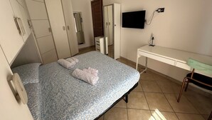 A bedroom with a bed, wardrobe, desk, and a TV. - "Stylish and modern stay a stone's throw from downtown close to all amenities" (Modena)
