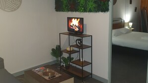 A modern living room with a flat-screen TV, a wooden coffee table, and a sofa. - 100m2 apartment between lakes and mountains (Nantua)