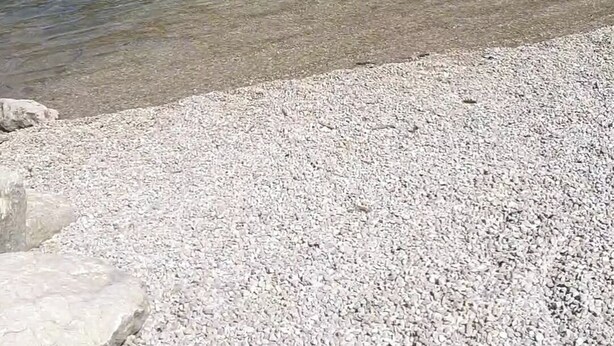 A pebble beach with clear water and a rocky cliff in the background. - 100m2 apartment between lakes and mountains (Nantua)