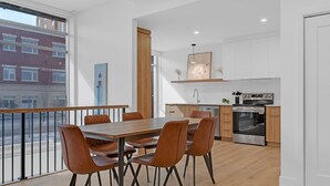 Eine moderne Küche mit Essbereich, Holzboden und Blick auf die Stadt.