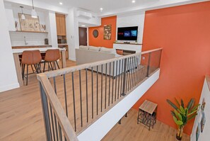 A modern apartment with a kitchen, dining area, living room, and a balcony. - Unit 102 - 2 Stories - 55" TV - Foosball - Downtown (Rimouski)