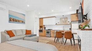 Un appartement moderne comprenant un espace de vie, une kitchenette et un coin repas.