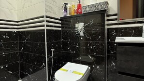 Un baño con inodoro, ducha y lavamanos.
