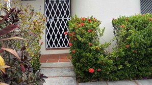 Un edificio con facciata bianca, tetto in tegole e una porta con il numero civico, oltre a una piccola finestra.