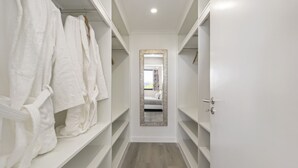 A narrow hallway with white lockers on either side and a mirror on the wall. - Camacho Studios - Green Room by Homie (Funchal)