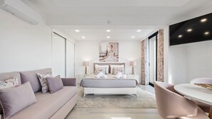 Une chambre moderne avec un grand lit, un canapé, une table à manger et un téléviseur.