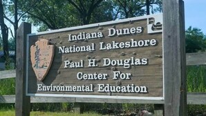 Un letrero de madera con el texto de Indiana Dunes National Lakeshore y el Paul H. Douglas Center for Environmental Education.