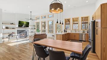 Una cucina moderna con mobili in legno, un'isola grande e un'area pranzo con sedie.