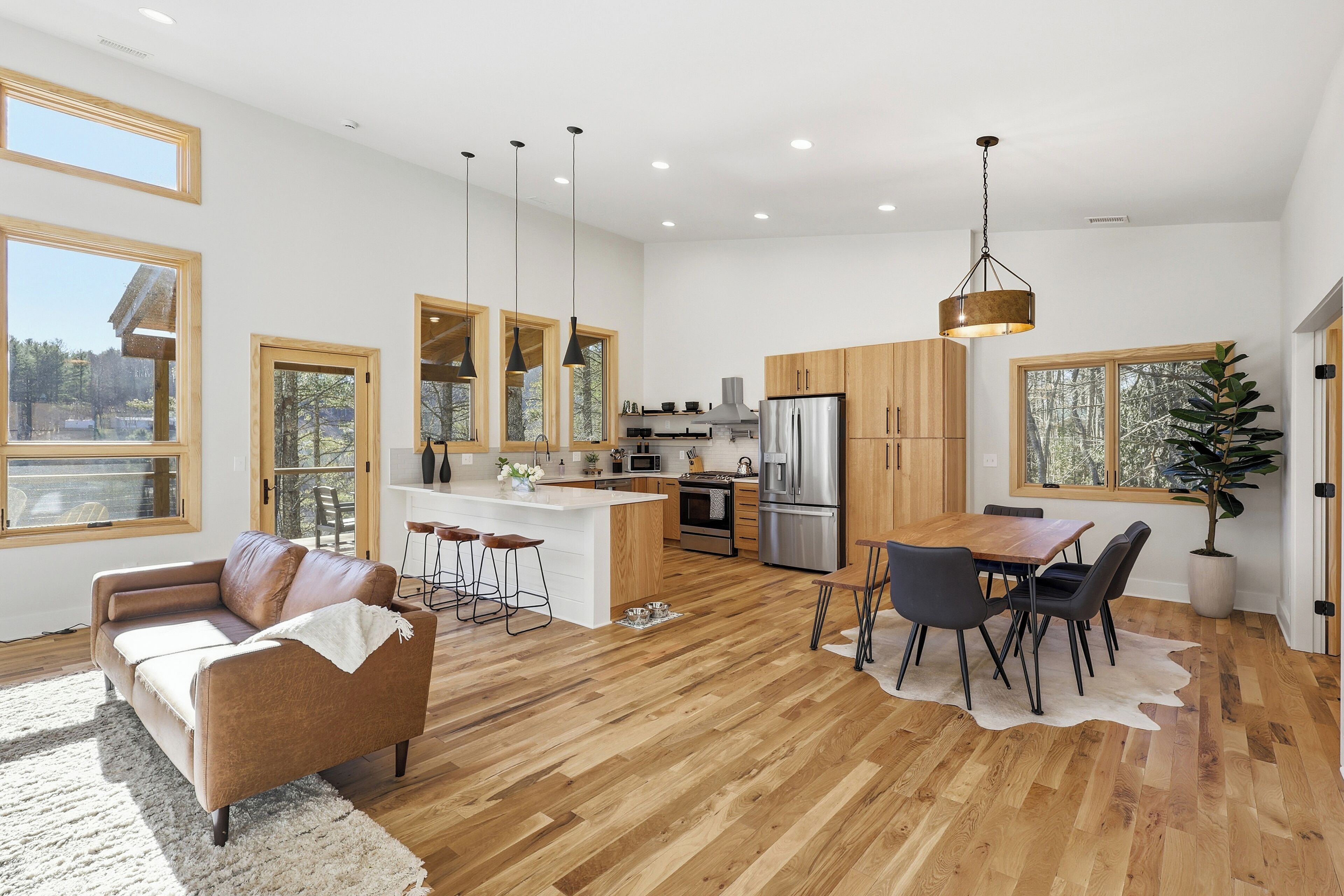 A spacious kitchen with wooden cabinets, a central island, and a dining area with a table and chairs.