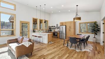A spacious kitchen with wooden cabinets, a central island, and a dining area with a table and chairs.