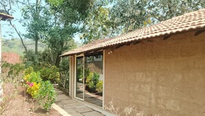 A rustic building with a tiled roof and a small porch. - Zennis Earth Stays (Mandrem)