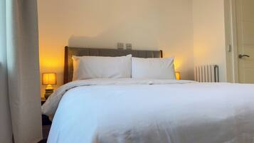 Tabla de planchar con plancha, internet y ropa de cama