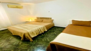 A room with two beds, a nightstand, a lamp, and an air conditioning unit. - Apartment near Maracanã Stadium, Rio de Janeiro, Brazil (Rio de Janeiro)