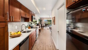 A modern kitchen with wooden cabinets, stainless steel appliances, and a white countertop. - SUMMER SALE! Relaxing Studio with Pool View Lanai in Kaanapali - Eldorado E206 (Lahaina)