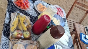 Un pique-nique avec divers aliments et condiments disposés sur une nappe à motifs.