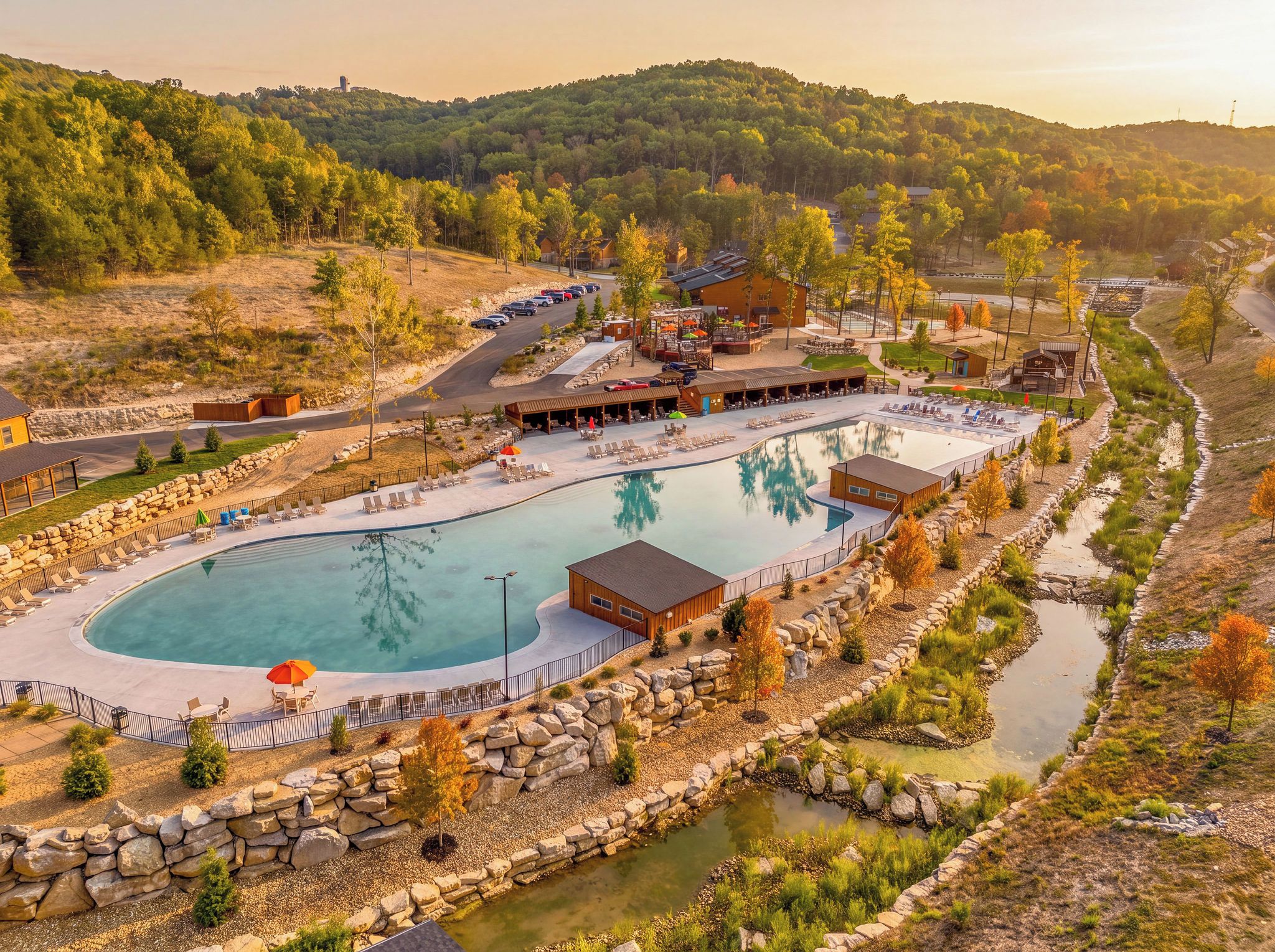 Un complejo turístico con una amplia piscina, zonas de estar al aire libre y vistas a las colinas circundantes.
