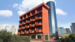 A modern building with a unique architectural design, featuring a red facade and a contrasting blue glass tower. - BLUEFROG HOTEL (Incheon)