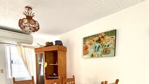 Ein Essbereich mit Holztisch und Stühlen, einem Schrank und einem Bild an der Wand.