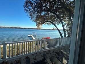 A lakeside view from a porch with a dock extending into the water. - Magician Lakefront - 7 bedrooms, 4.5 baths, screened in porch and coffee bar. (Dowagiac)