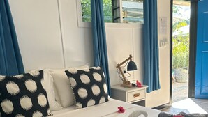 Ένα δωμάτιο ξενοδοχείου με ένα κρεβάτι, ένα κομοδίνο, ένα φωτιστικό και θέα προς τα έξω.