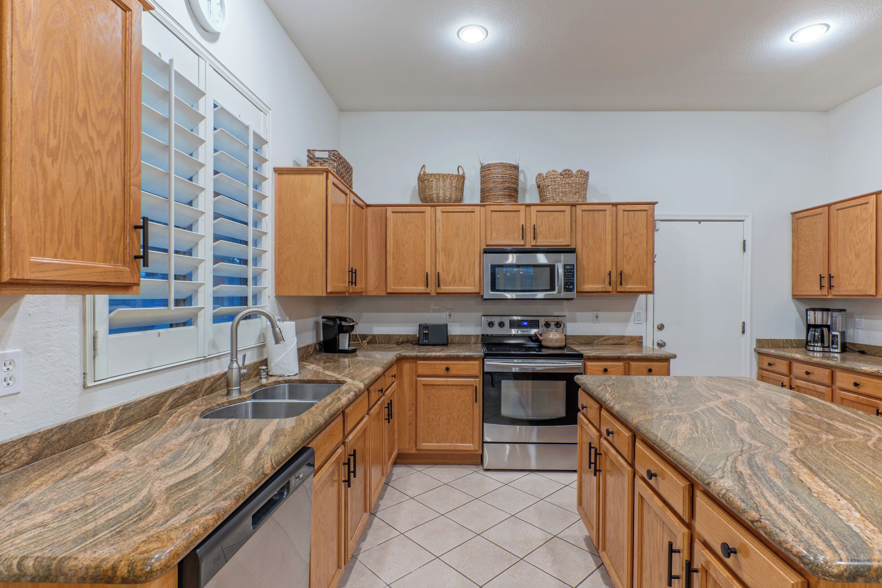 A kitchen with wooden cabinets, a stainless steel microwave, a stove, and a dishwasher.