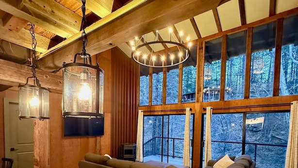 Ein gemütliches Interieur mit Holzboden, einem großen Fenster und einer Couch.