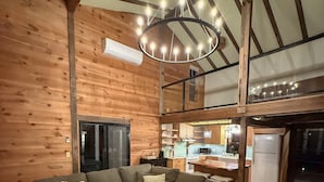 Ein gemütliches Wohnzimmer mit einem Ecksofa, einem Couchtisch aus Holz und einer Chandelier.