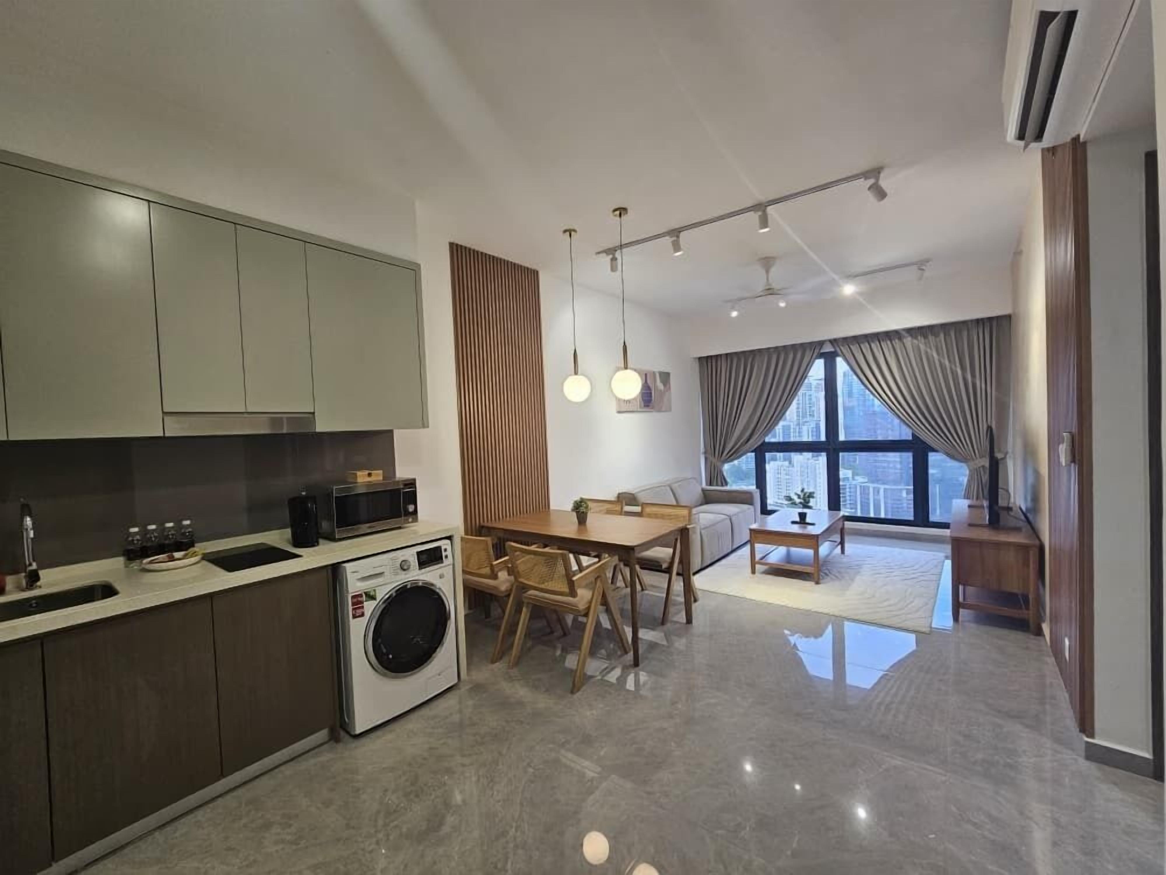 A modern kitchen with built-in appliances, a dining area with a wooden table and chairs, and a large window offering a city view.