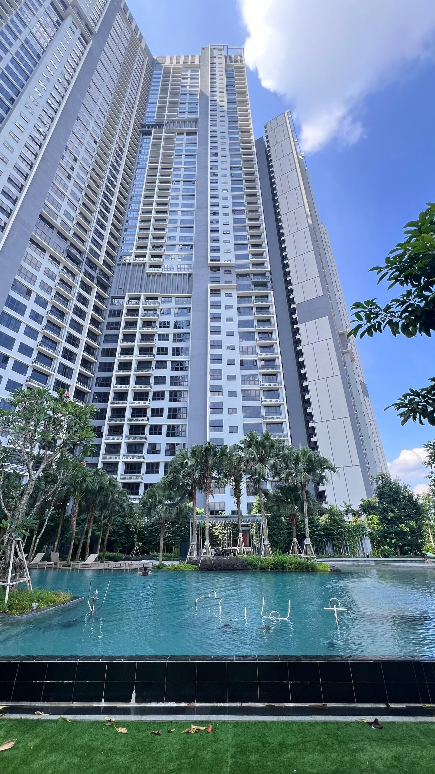 Ein Hochhaus mit einem Schwimmbecken im Vordergrund.