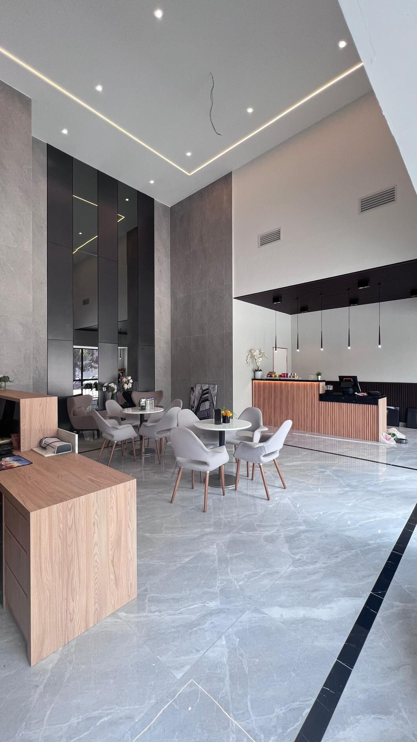 Een modern interieur met een receptiebalie, zithoek en een keukenwerkblad.