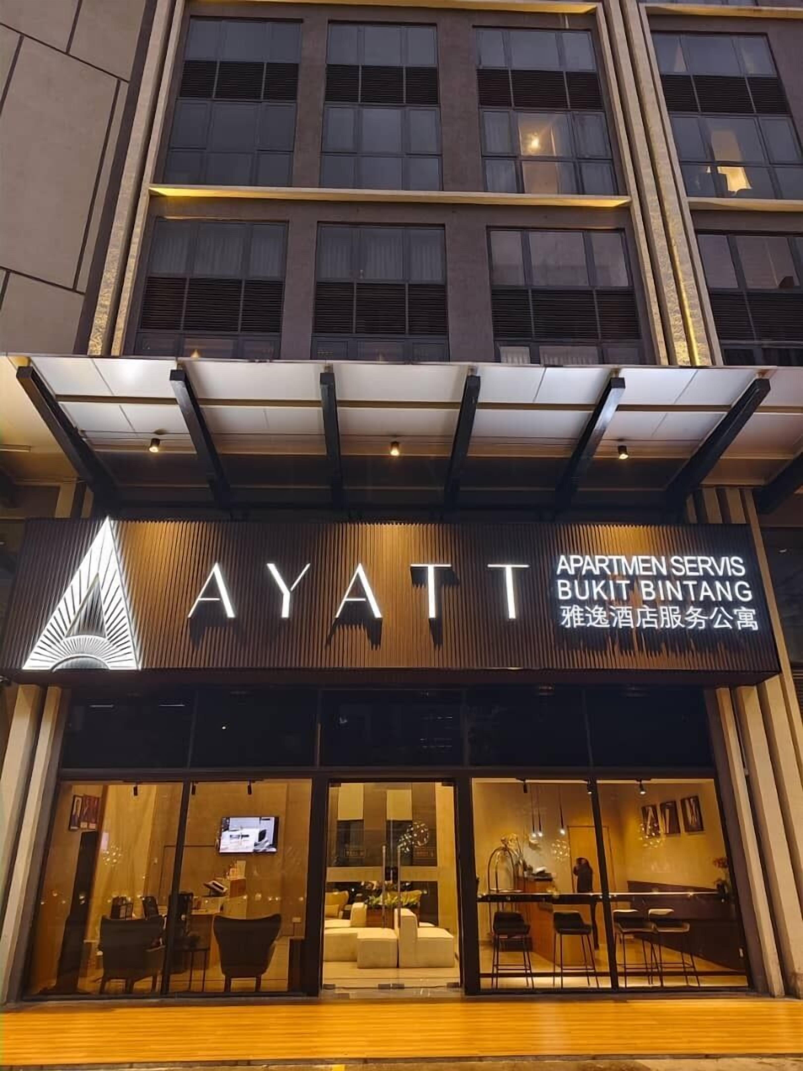 The exterior of the Ayatt hotel with a modern facade, large windows, and a prominent sign.