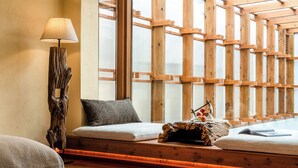 A cozy seating area with a wooden bench, a lamp, and a cushion. - Shangri-La Nazhu Tibetan Mansion Hotel (Deqin)