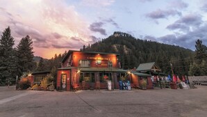 A rustic lodge with a prominent sign, a small attached building, and a parking area.