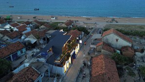 Eine Küstenstadt mit Strand, Häusern mit roten Ziegeldächern und einer Straße, die zum Strand führt.