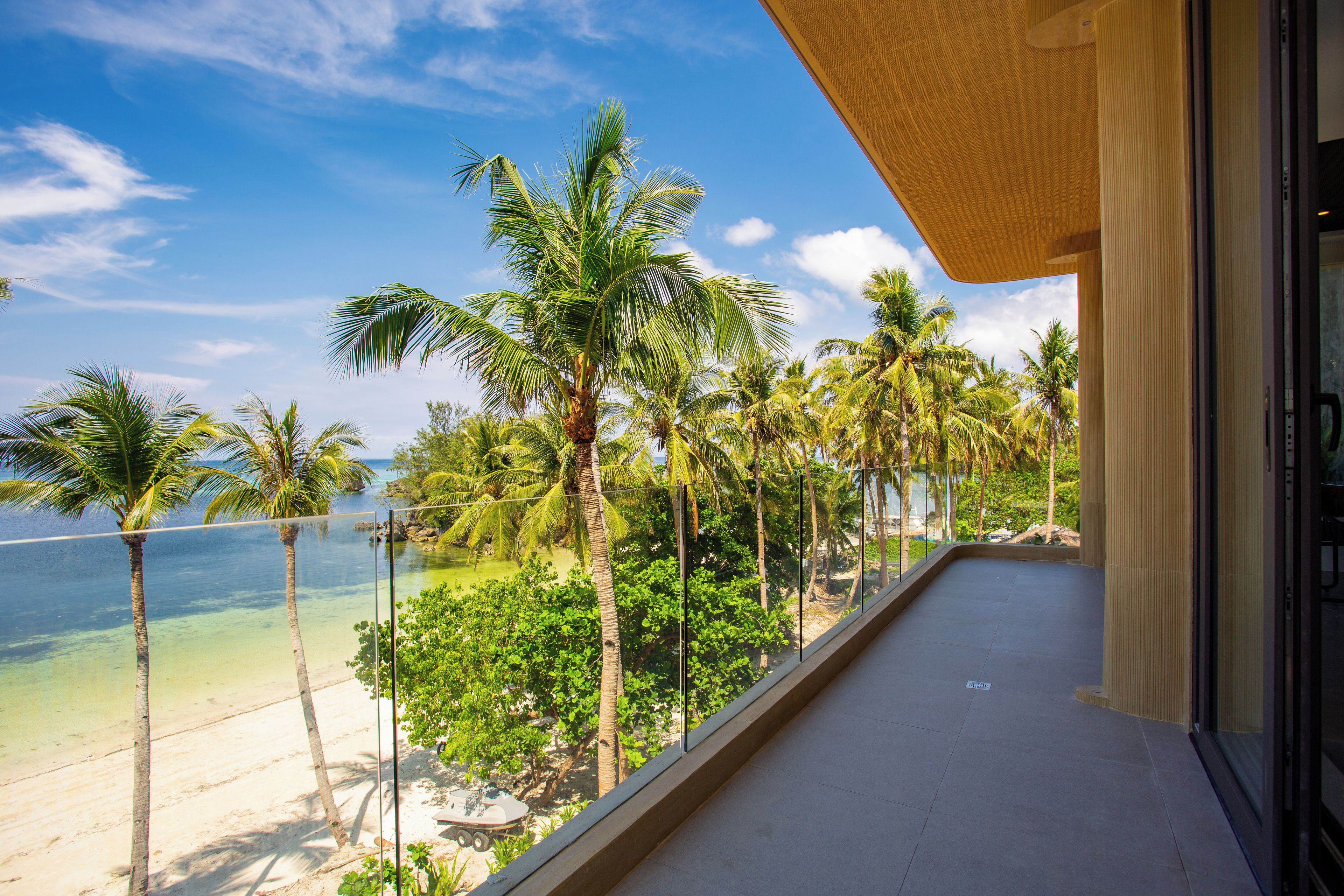 Un balcón con vista a una playa y palmeras.