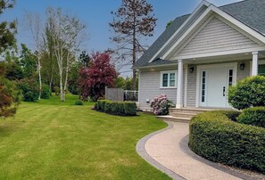 A residential house with a well-maintained lawn, a curved driveway, and a front porch. - Large Private Riverfront in Stanley Bridge, centrally located 4 bdrm, 3.5 ba (Stanley Bridge)