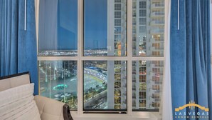 A high-rise building with multiple balconies and a view of a cityscape at night. - MGM Signature-1Br Work Desk Sphere Balcony Suite (Las Vegas)