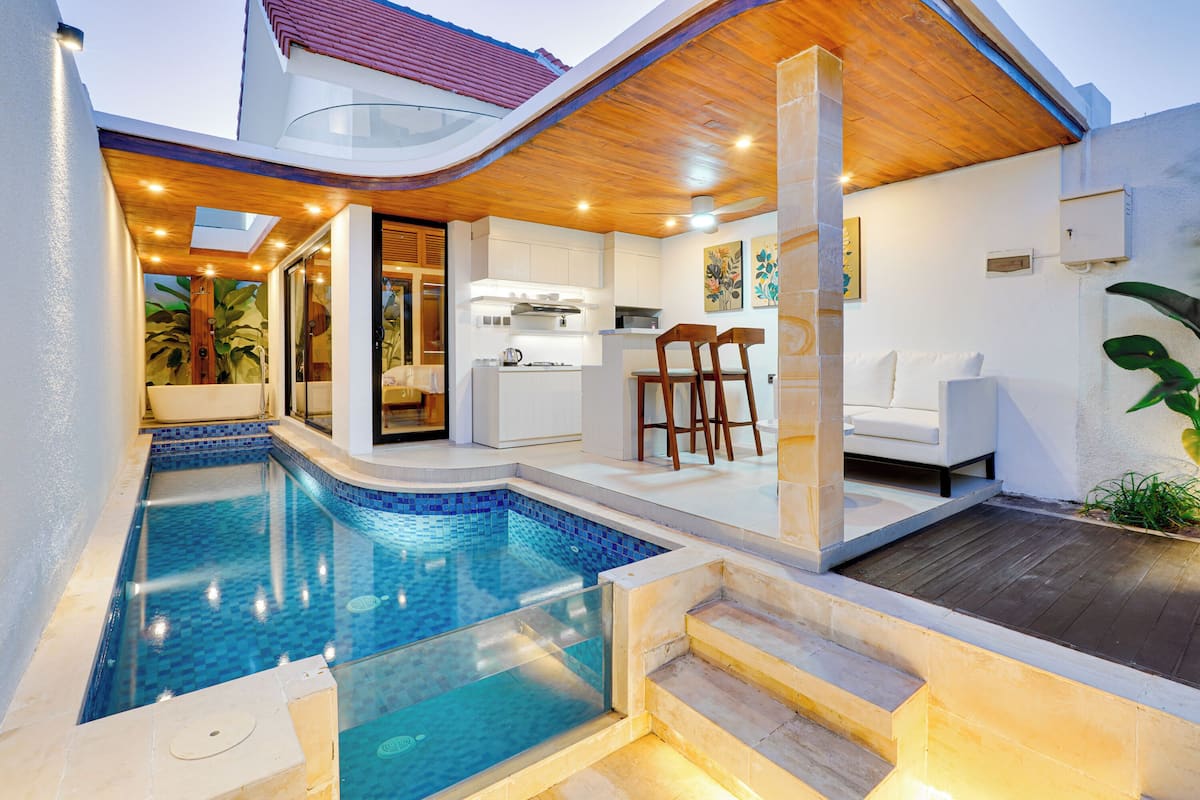 A modern house with a swimming pool, a kitchen, and a dining area.