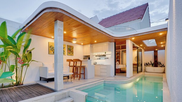 Una casa moderna con piscina, comedor y cocina.